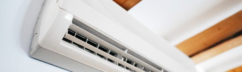 White air conditioning unit mounted onto a white wall